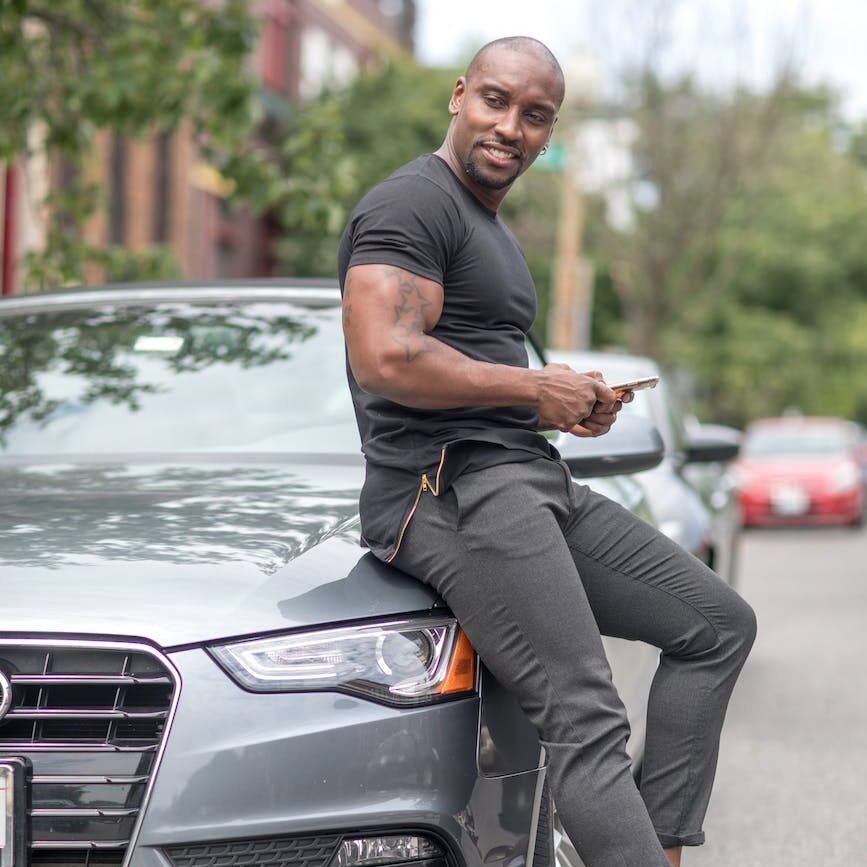 man sitting on the hood of a car